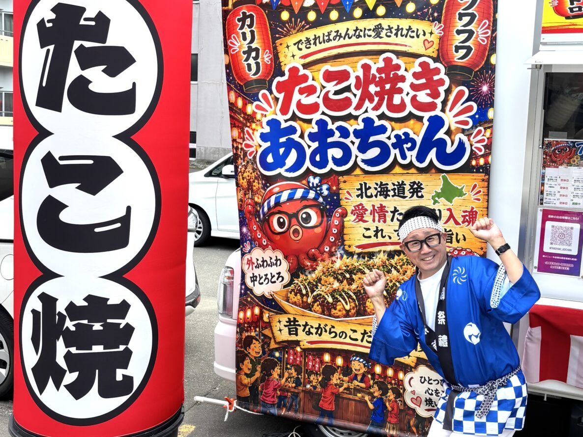 法被と鉢巻き姿でポーズをとる、たこ焼きあおちゃんの店主