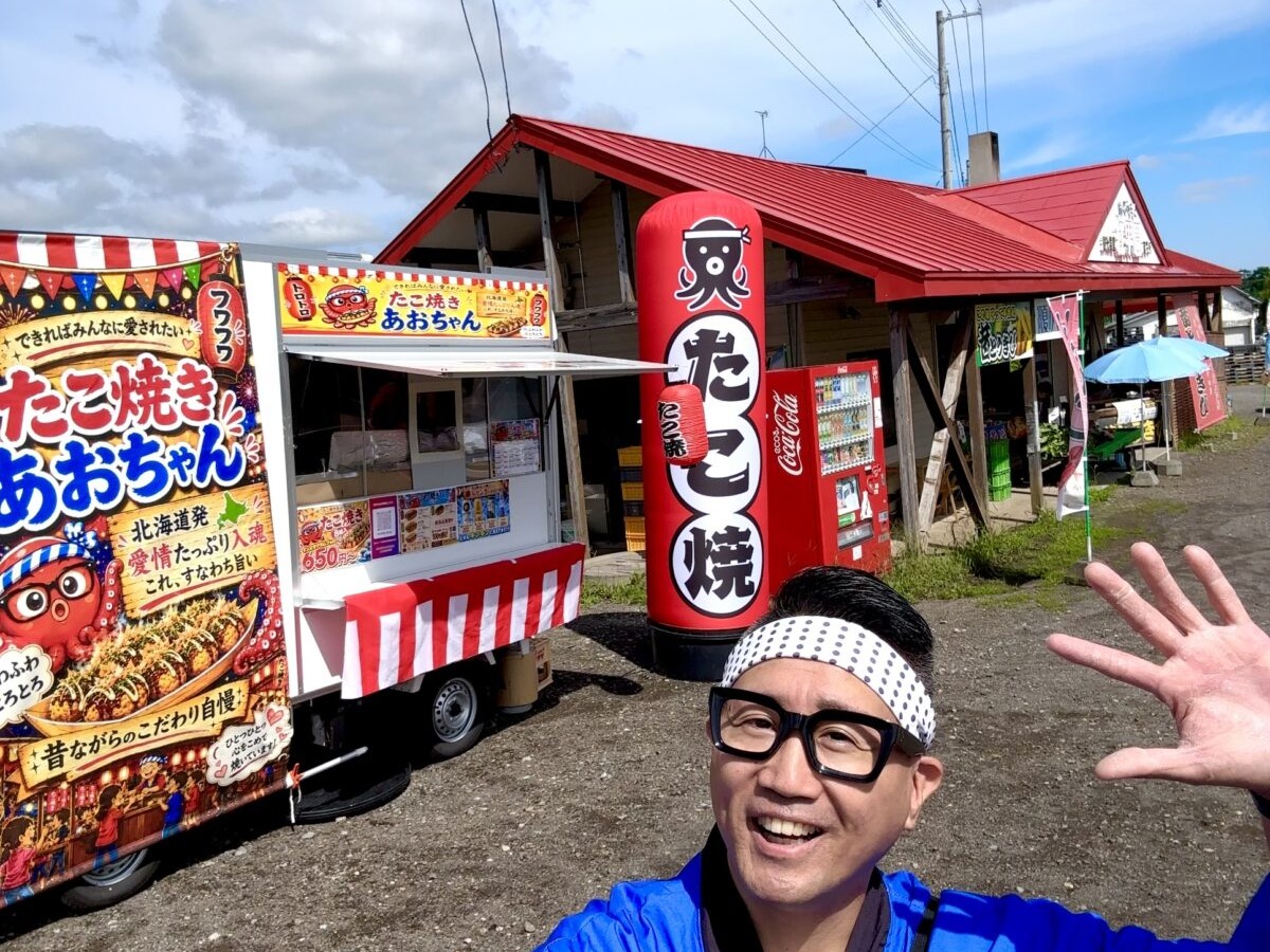 青空の下、出店先でキッチンカーと並ぶ店主